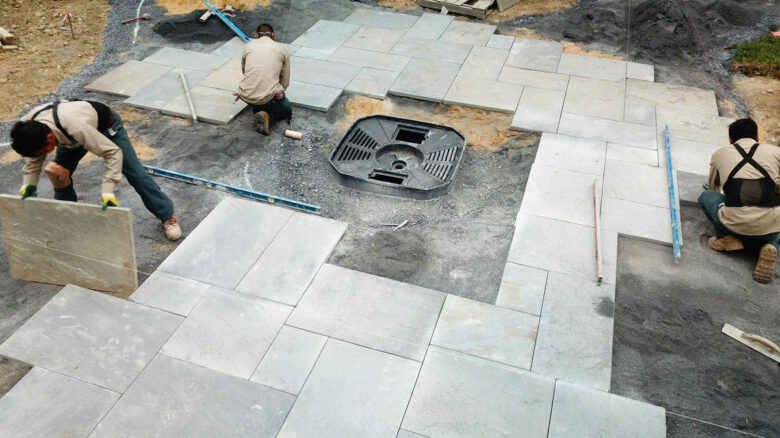 Landscaping installation of patio pavers around a custom fire pit