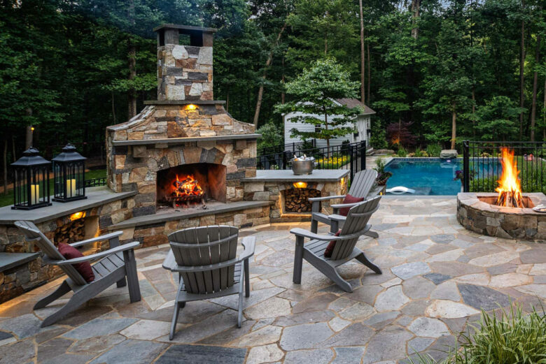 Outdoor fireplace and firepit with seating overlooking the pool in Carroll County